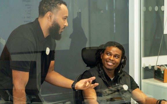 A TPS colleague talking with a team member at a desk